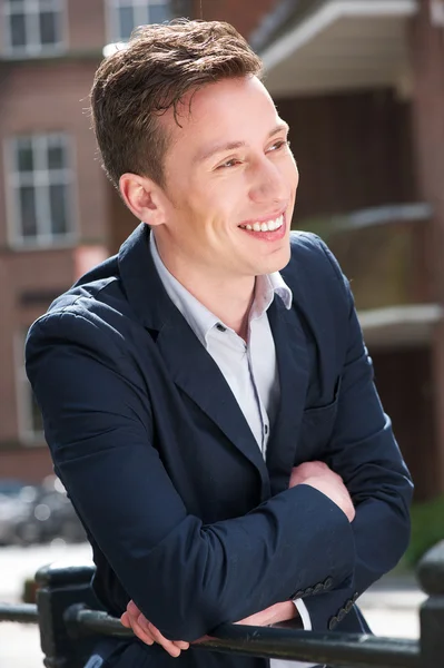 Handsome young man smiling outdoors — Stock Photo, Image