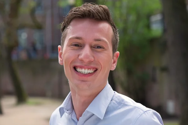 Attractive young man smiling outdoors — Stock Photo, Image