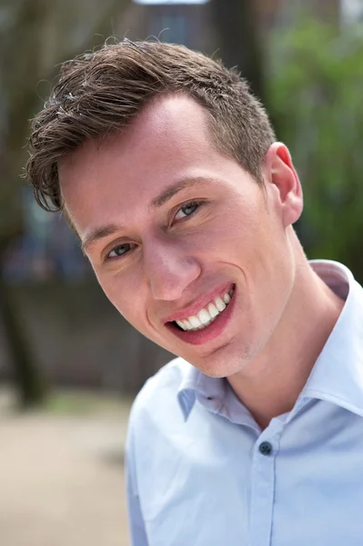 Retrato de un joven confiado sonriendo al aire libre — Foto de Stock