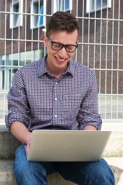 Porträtt av en glad student som arbetar på laptop utomhus — Stockfoto