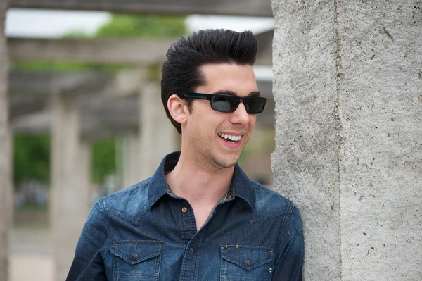 Hombre guapo sonriendo al aire libre con gafas de sol — Foto de Stock