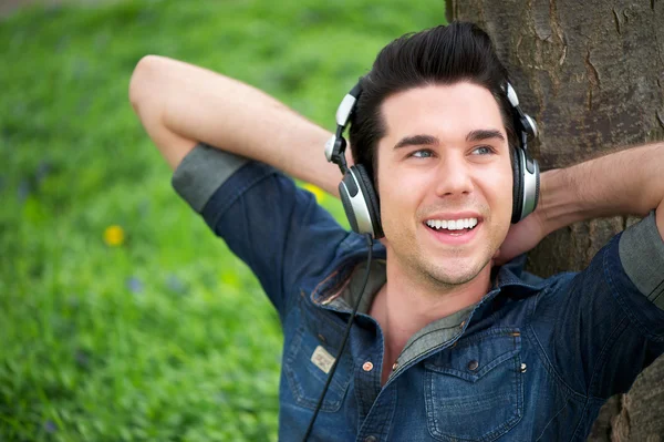 Portrait of a happy man listening to music outdoors — Stock Photo, Image