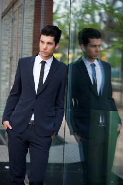 yakışıklı işadamı cam bina karşı yaslanmış