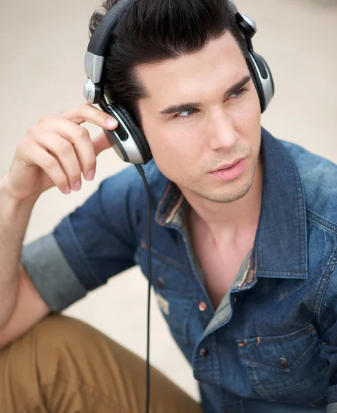 Portréja egy jóképű fiatal férfi zenehallgatás fejhallgató — Stock Fotó