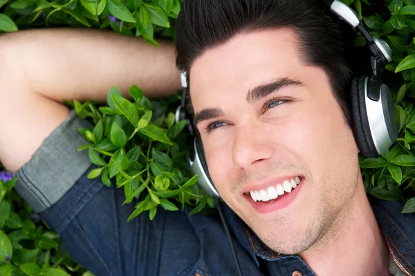 Portrait of a happy young man relaxing with headphones — Stock Photo, Image