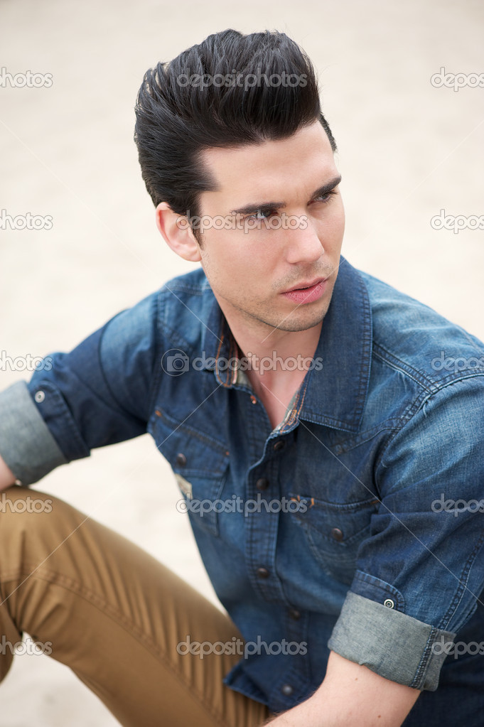 Male fashion model sitting outdoors