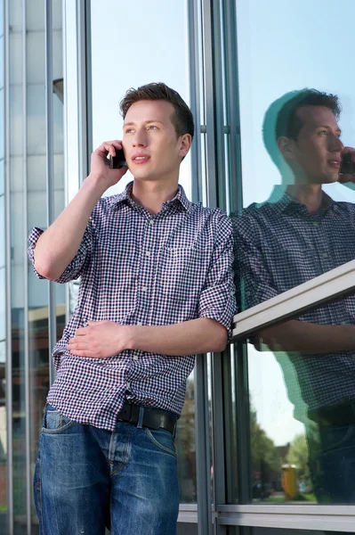 Mladý muž mluví na mobilní telefon venku — Stock fotografie
