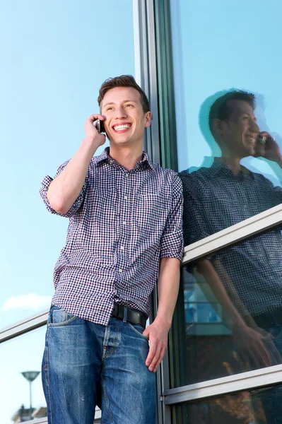 Joyeux jeune homme sur téléphone mobile en plein air — Photo