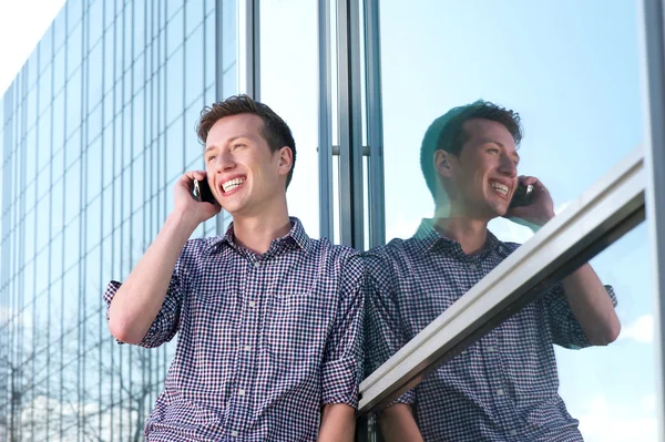 Young man talking on mobile phone outdoors — Stock Photo, Image