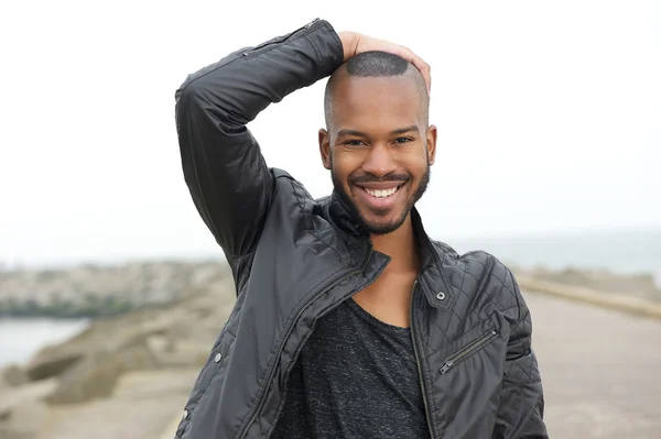 Bonito jovem negro sorrindo ao ar livre — Fotografia de Stock