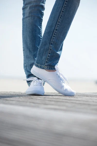 Retrato de pernas com jeans e sapatos brancos ao ar livre — Fotografia de Stock