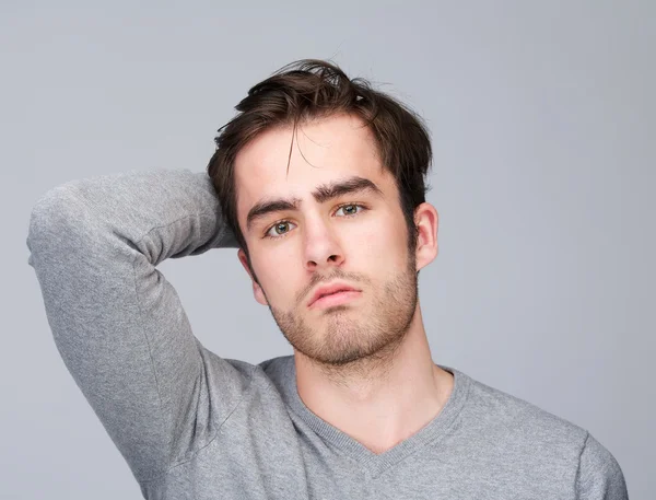 Portrait of a handsome young man with hand in hair — Stock Photo, Image