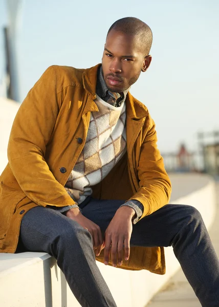 Handsome male fashion model sitting outdoors — Stock Photo, Image