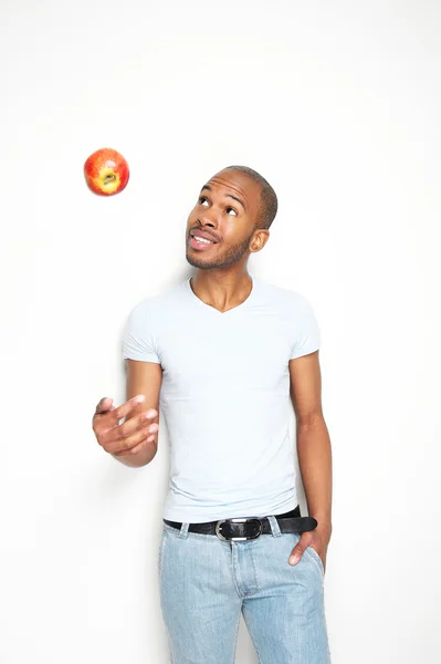 Joven negro lanzando una manzana roja —  Fotos de Stock