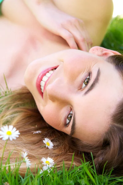 Açık havada çiçekler ile gülümseyen genç bir beyaz kadın Telifsiz Stok Imajlar