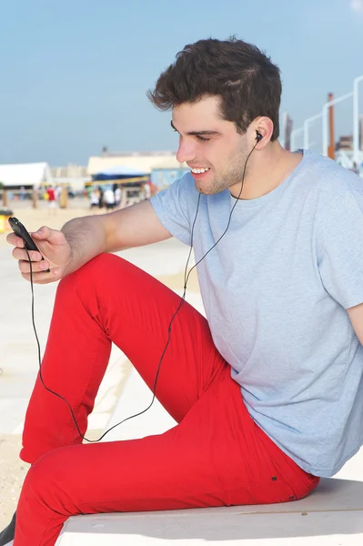 Felice giovane uomo che ascolta musica su lettore mp3 — Foto Stock