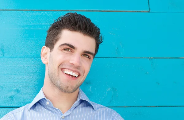 Retrato de un joven guapo sonriendo y mirando hacia otro lado — Foto de Stock