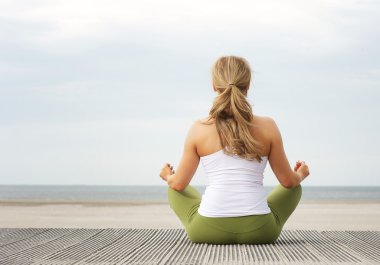 Dikiz yoga poz Plajı'nda oturan genç kadın portresi