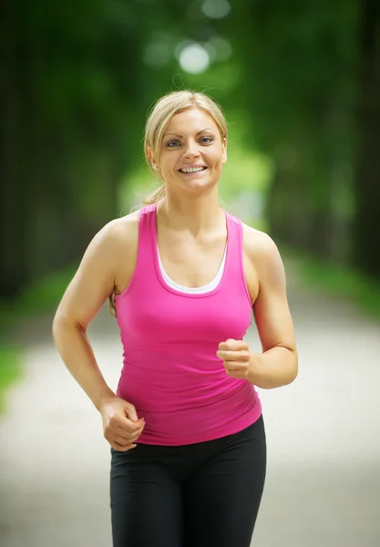 Porträt einer aktiven jungen Frau beim Joggen im Park — Stockfoto