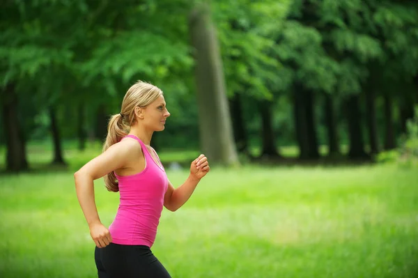 Retrato de uma jovem mulher saudável correndo no parque — Fotografia de Stock