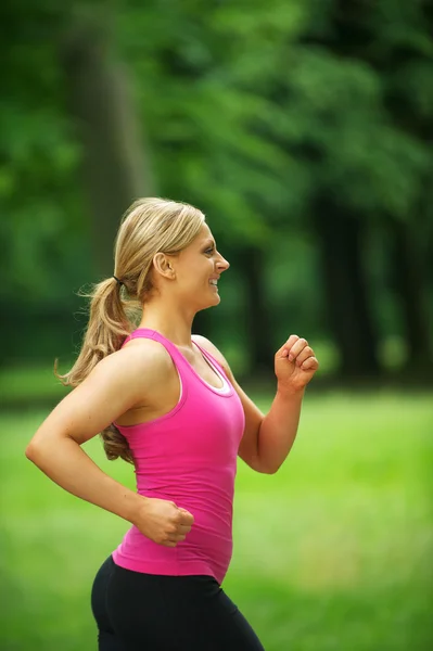 Sportliche junge Frau joggt im Park — Stockfoto