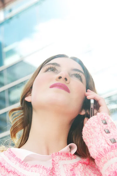 Porträtt av en vacker ung dam som pratar i mobiltelefon i staden — Stockfoto