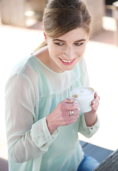 Genç kadın gülümseyerek ve kahve keyfi — Stok fotoğraf