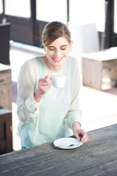 Sorridente giovane donna godendo di una tazza di caffè all'aperto — Foto Stock