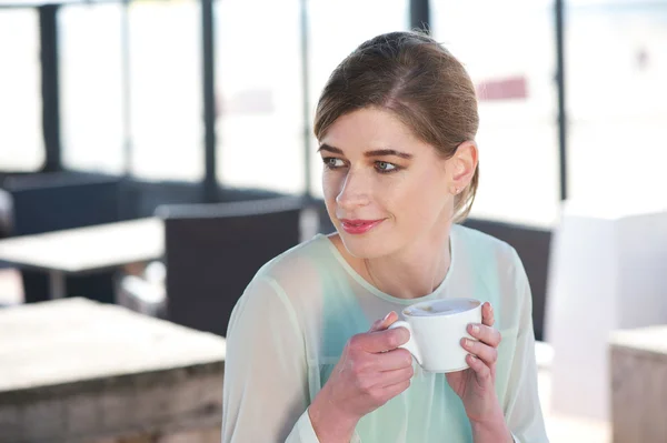 Retrato de uma jovem mulher desfrutando de uma xícara de café ao ar livre — Fotografia de Stock