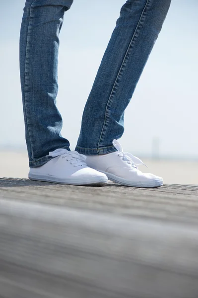 Kvinnliga ben står utomhus i bekväma vita skor — Stockfoto