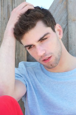 açık havada el saç ile oturan genç adam