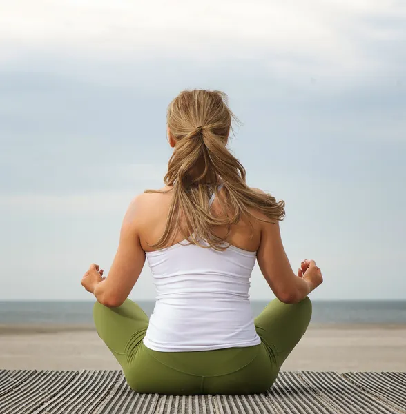 Kumsalda yoga pose arka görüş genç kadın