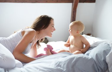 Anne ve bebek yatağı üzerinde oynama