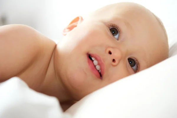 Portret van een schattige baby liggend in bed — Stockfoto