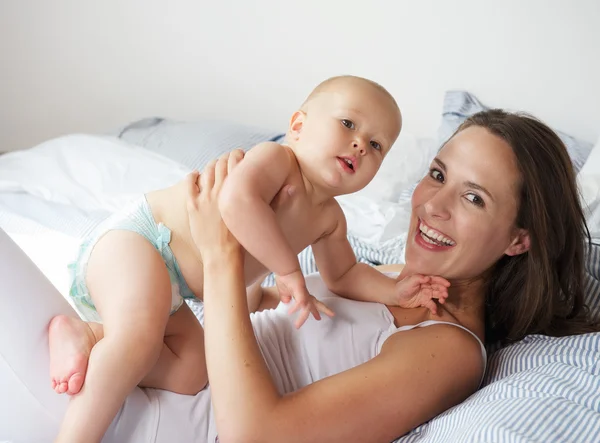 Mother holding baby and smiling — Stock Photo, Image