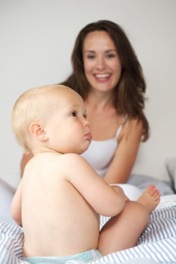 Mutlu anne ve bebek yatakta.