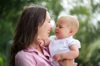 mutlu anne ve birbirine bakarak şirin bebek