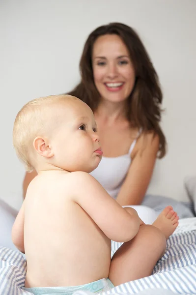 Happy mother with baby on bed — Stock Photo, Image