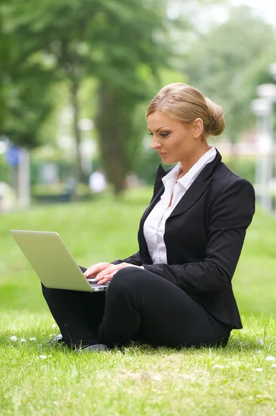 Όμορφης επιχειρηματικής γυναίκα που κάθεται με το laptop στο πάρκο — Φωτογραφία Αρχείου
