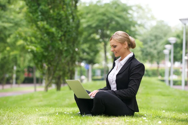 Affärskvinna arbetande utomhus på laptop — Stockfoto