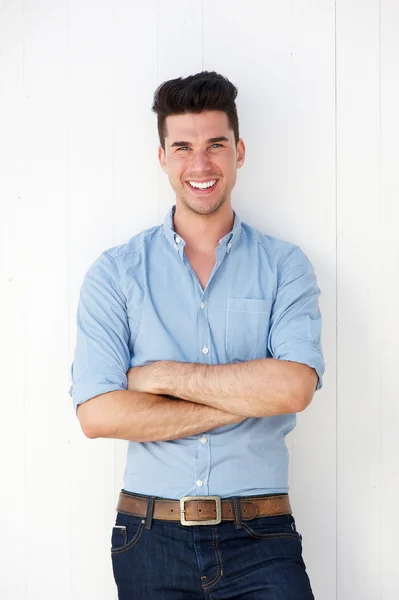 Glücklicher junger Mann lächelt vor weißem Hintergrund — Stockfoto