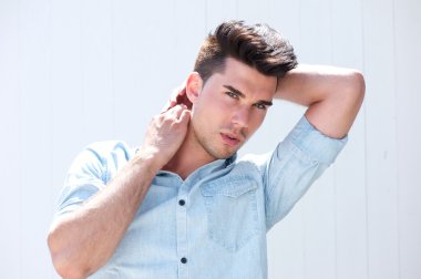 Handsome male fashion model with hands in hair