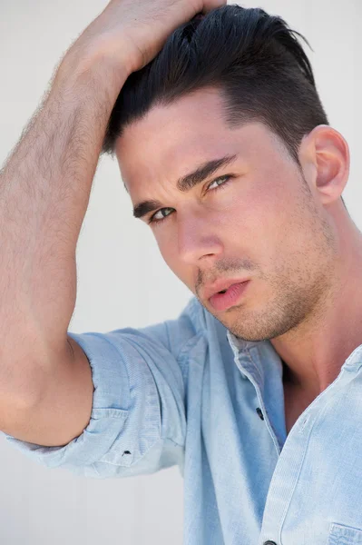 Portrait of an attractive young man with hand in hair — Stock Photo, Image