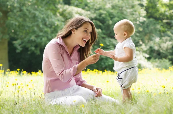 Mãe bonita com bebê brincando no parque — Fotografia de Stock