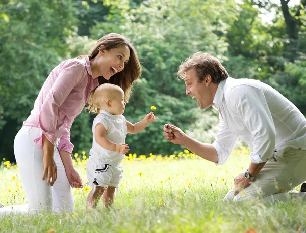 Lycklig familj med barn som ger blomman till far — Stockfoto