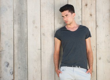 iyi görünümlü genç adam açık havada duvara karşı ayakta