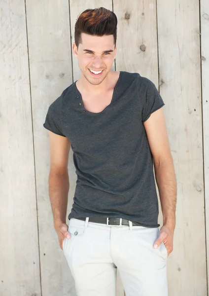 Handsome young man laughing with hands in pocket — Stock Photo, Image