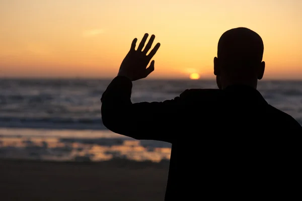 Silhouette maschile che ondeggia al tramonto in spiaggia — Foto Stock