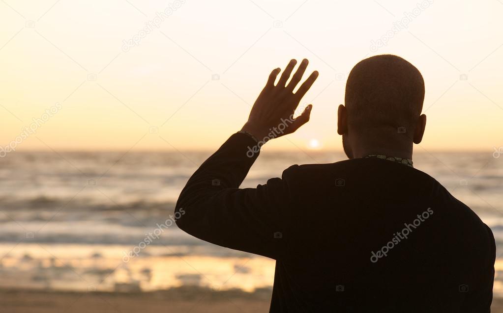 Man waving at the sunset