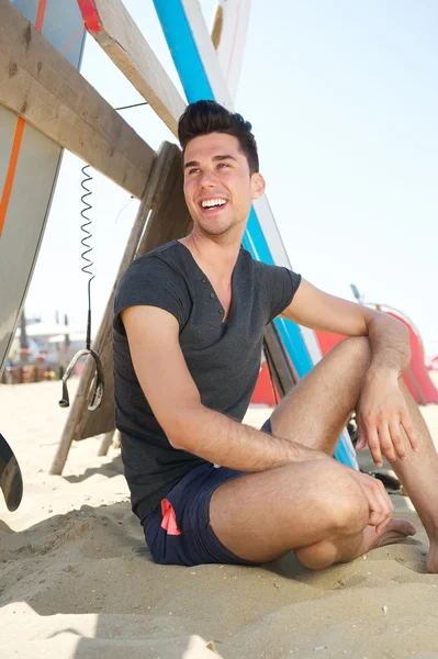 Joyeux jeune homme souriant à la plage — Photo